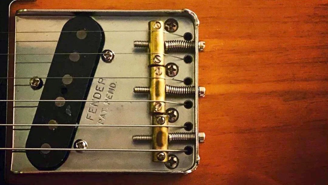 Close-up of a Fender Telecaster guitar bridge and pickup.